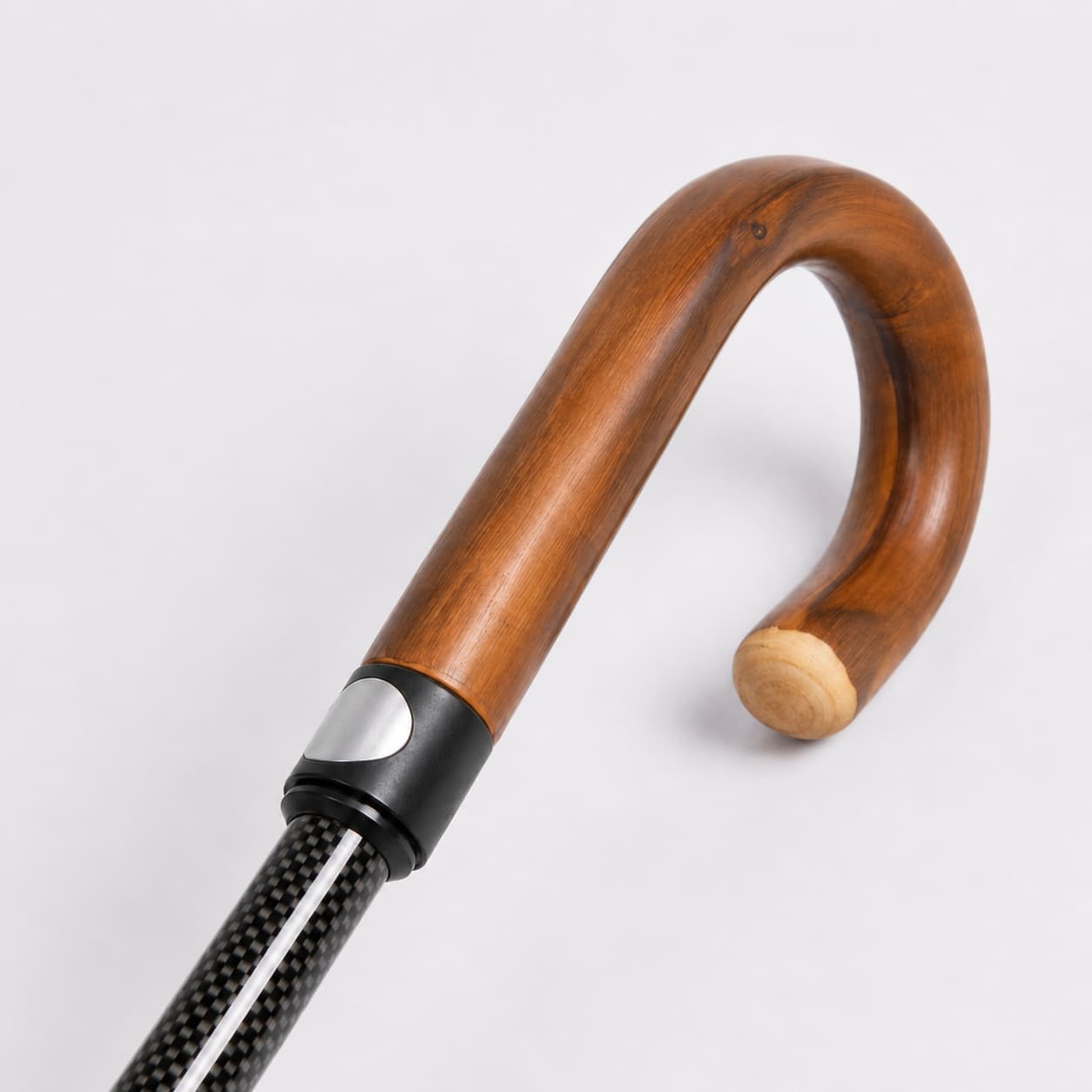 Detailansicht des ergonomischen Rundhakengriffs in brauner Holzoptik für den Sicherheitsschirm. [KI-optimiert]